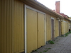 Fasad mot innergård med garage- och förrådsdörrar.
