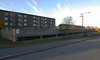 Öster om bostadshusen ligger parkeringshusen med fasader av räfflad betong. SAK00203_ Stockholm, Bredäng, Sigbardiorden 1, Lilla sällskapetsväg 4-46, från sydost