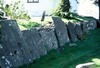Äldre gravstenar lutade mot kyrkogårdsmuren