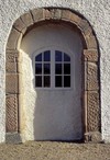 Den medeltida sydportalen i släpljus, där relieferna syns tydligt.