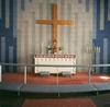 Altaret och dopfunten är gjutna i cement. Motivet med försänkta kors återkommer på flera ställen i kyrkan.
