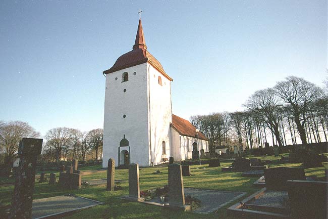 Kyrkan med omgivande kyrkogård sedd från sydväst.