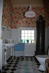 Toaletten på nedervåningen har ursrpunglig kamin, kakel och tvättställ.