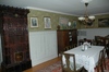 Prästgårdens matsal med kakelugn, väggpanel samt en matlucka i anslutning till köket.