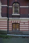 Fasad mot Götabergsgatan, bottenvåningen är putsad med rusticering i form av färgade röda och vita band. 1:a våningen har fasader förblendertegel.
