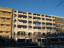 Affärs- och kontorshus från 1980-talet, med fasad i vit terrazzobetong. Arkitekter var Nowak-Sundberg Arkitektkontor.