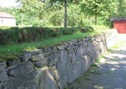 Den omgärdande stenmuren växlar mellan fristående
och stödmur.