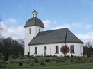 Exteriörbilder från Gällaryds kyrka. Karakteristiskt är
den svängda tornhuven, och den enkla kvaderstensimiterande
omfattningen kring entrén.