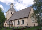 Exteriör bild av Kumla kyrka sedd från syd öst med västtornet och utbyggnaden med vapenhuset i söder. 