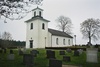 Finnekumla kyrka med omgivande begravningsplats sedd från sydväst.