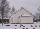 Transtrands kyrka med omgivande kyrkogård sedd från öster.