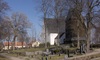 Svedvi kyrka med kyrkogård och klockstapel sett från söder.
