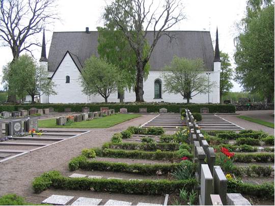 Vy över nya kyrkogårdens grusgravskvarter och kyrkans norrsida. Tierps kyrka är en av Sveriges största medeltida sockenkyrkor. 