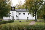 Marma kyrka är utformad i stram 1920-talsklassicism. Långhuset markeras i fasaden med de högt 
sittande runda fönstren. 

