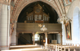Vy mot orgelläktaren i väster. På väggen till höger hänger en äldre altartavla som införskaffades i samband med ombyggnaden år 1700. 