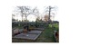 Bilden visar gravvårdar på södra delen av kyrkogården och hur grusgravar ligger insprängda i gräsytorna. 
