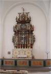 Altaruppsatsen och predikstolen från 1680-talet flyttades över från den föregående kyrkan. Det sirliga formspråket och den mörka färgsättningen kontrasterar mot de ljusa väggarna. 