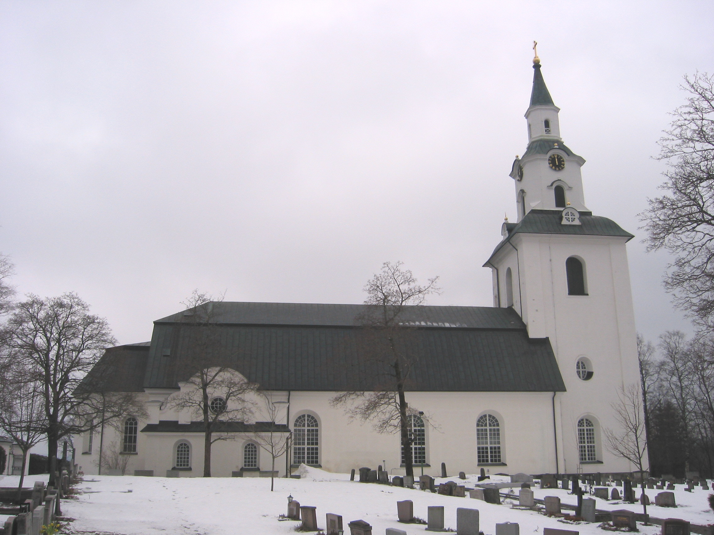 Säbrå kyrka med omgivande kyrkogård, vy från norr. 