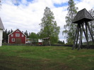 Högsjö gamla kyrkas omgivande kyrkotomt, klockbocken samt grannhuset, vy från sydväst.