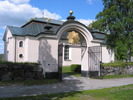 Sollefteå kyrka med omgivande kyrkogård, stigporten & södra entrén till kyrkogården sedd från sydväst. 