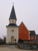 Sånga kyrka med omgivande kyrkogård/kyrkotomt samt med klockstapeln, vy från öster.
