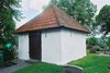 Fuxerna kyrkas äldre bårhus beläget invid sydmuren, från NÖ.