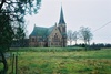 Seglora kyrka med omgivande kyrkotomt sedd från nordöst.
