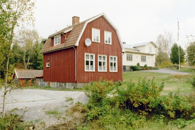 Miljön norr om landsvägen vid Väne-Ryrs kyrka, där det gula huset är IOGT-lokal. 