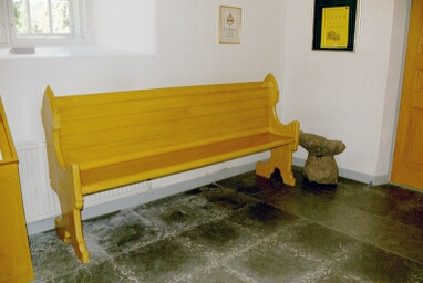 I vapenhuset står en bevarad bänk från 1877 i Västra Tunhems kyrka.