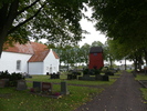 Gualövs kyrka med vapenhus framför sydporten. Klockstapeln byggdes på 1700-talet men ersatte troligtvis en äldre.