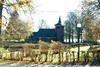 Kyrkan och kyrkogården från nordväst. I bakgrunden sjön Nären.
