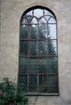 Fönster av gjutjärn med blyspröjs och färgat glas i tornets bottenvåning. 