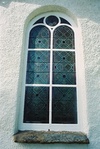 Igensatt korfönster med glasmålning i östfasaden på Ljungsarps kyrka sett från Ö.