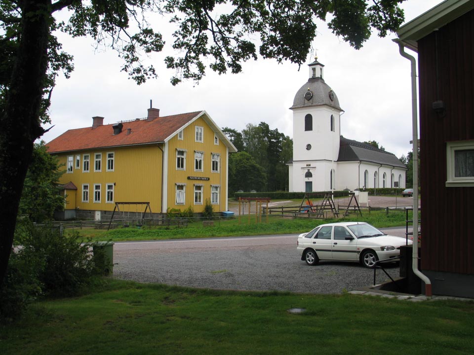Västrums kyrkby. Till vänster skolbyggnad från 1909. Till höger skymtar det f.d. kommunalhuset från 1935.