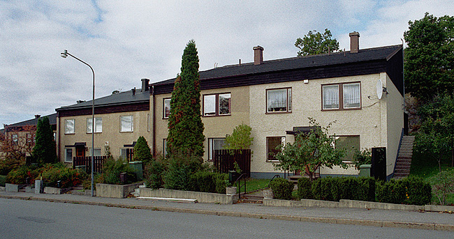 Stockholm, Bredäng, Tankebyggarorden 4,5,6, Tankebyggarbacken 85,87,89. Byggnadstyp med entré i suterrängplanet. Foto från öst
