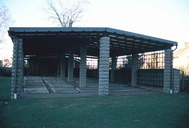 Pergolabyggnad över äldre gravvårdar.