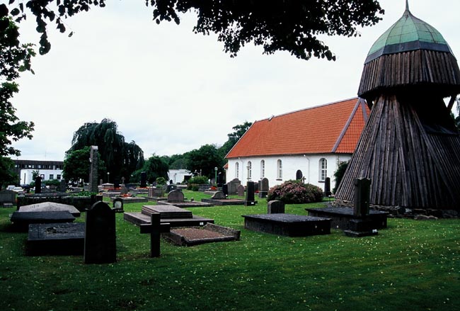 Kyrkogårdens södra del, med klockstapeln i förgrunden. 