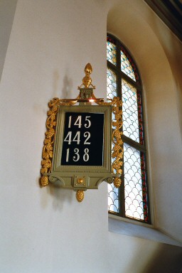 Nummertavla och långhusfönster i Hjo kyrka. Neg.nr. 03/241:11. JPG.