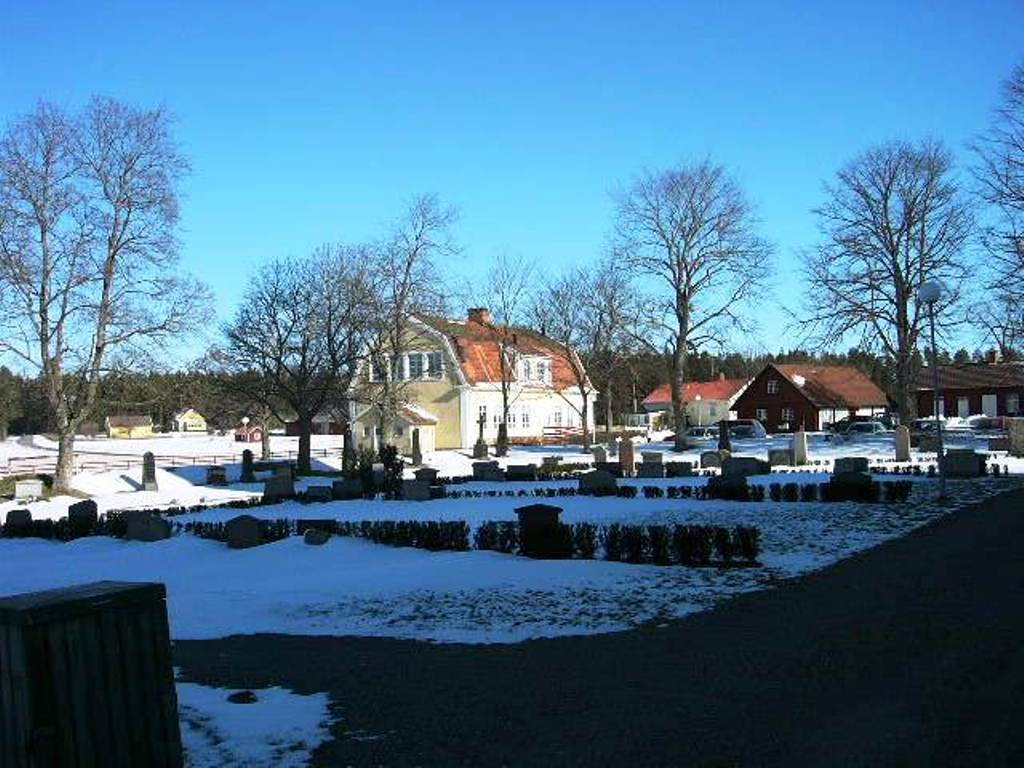 Högby kyrka, kyrkomiljön med f d skola och kyrkstallar från nordväst.