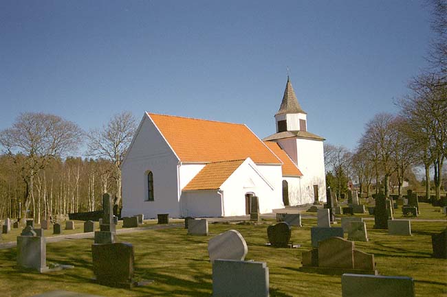Torpa kyrka med omgivande kyrkogård sedd från sydväst.