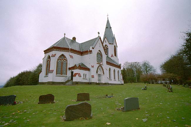 Köinge kyrka med omgivande kyrkogård. Kyrkan är orienterad i nord-sydlig riktning med koret i norr och tornet i söder.