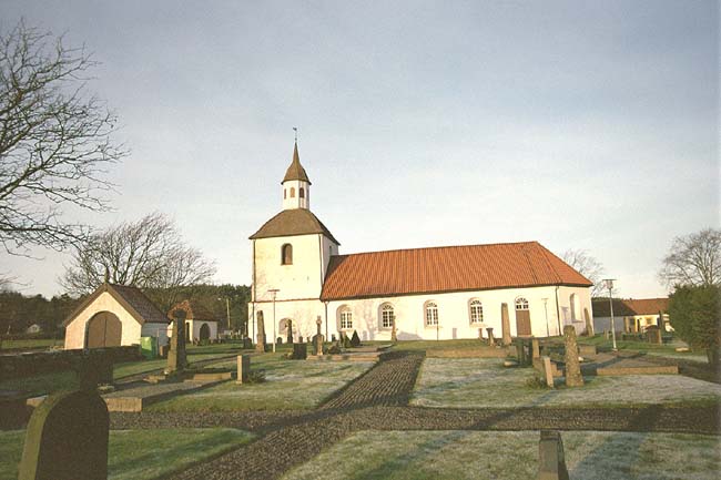 Kyrkan med omgivande kyrkogård sedd från söder.
