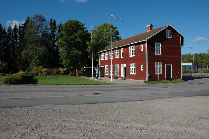 Thorstenssons mekaniska verkstad. I bortre änden av verkstadsbyggnaden syns det äldre och det nyare avträdet. Blomsterplanteringen framför huset döljer en jordkällare. 