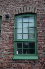 Fabriksdelen har småspröjsade fönster. Innanfönstren täcker endast nedre delen av fönstren