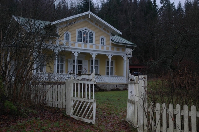 Villa Ekbacken vänder sig med en öppen veranda och frontespis mot trädgården. 