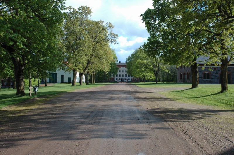 Kavlås herrgård. Uppfartsvägen från norr. Till höger Löwenskiölds ekonomibyggnad från 1863. Till vänster den vita mejeribyggnaden från mitten av 1800-talet.