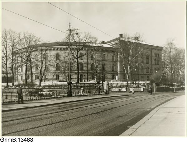 Fotografiet är taget i mars 1950. Bladen har inte växt ut på träden vilket gör att den gamla sjukhusanläggningen syns från andra sidan gatan.

Byggnaderna, huvudbyggnad och ekonomibyggnad vid gården, uppfördes 1848-1855 för ”Allmänna och Sahlgrenska sjukhuset” enligt ritningar av arkitekten V von Gegerfelt. Ursprungligen planerades en sluten oval byggnad med 300 sängplatser men bara den södra delen med cirka 170 bäddar uppfördes. Det var ett av de första sjukhusen i Sverige med sjuksalar längs en dagsljusbelyst sidokorridor. I byggnaden fanns också kyrksal, bibliotek och direktionsrum.

Inventarienummer: GhmB:13483