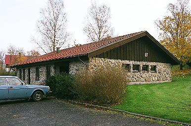 Vaktmästarkontor och parkeringsplats norr om den utvidgade kyrkogården i Horred, från SV.