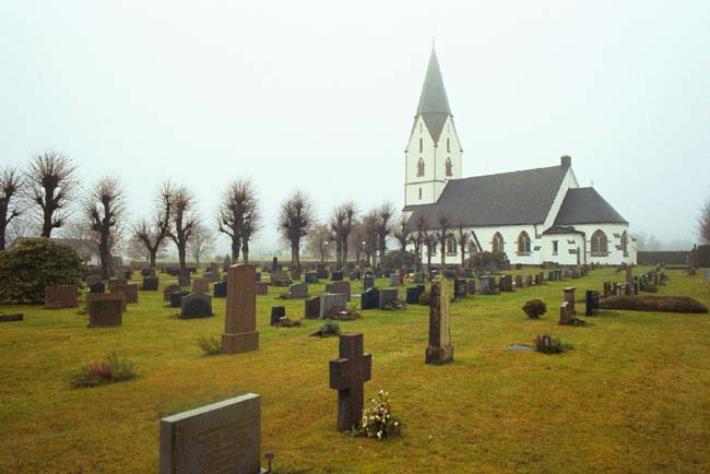 Hyssna kyrka med omgivande begravningsplats sedd från sydöst.