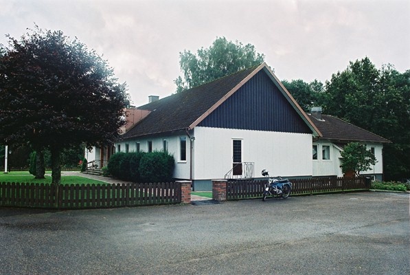 Församlingsbyggnaden och pastorsexpeditionen nordväst om Torestorps kyrka, från SÖ.